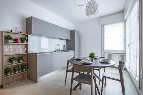 cocina y comedor con mesa y sillas en C-Apartment Zabarella terrace en Padova