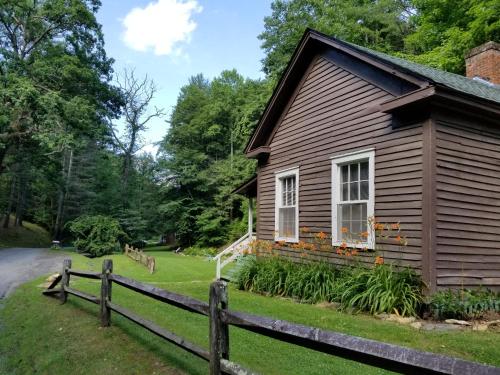 a house with a fence in front of it at The Cabins at Healing Springs in Crumpler