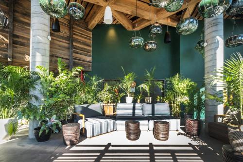 a lobby with couches and potted plants at MADE Hotel in New York