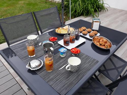 a picnic table with food and drinks on it at Chambre d'hôtes du Pin in Pey
