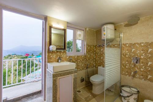 a bathroom with a sink and a toilet and a window at Zostel Homes Theog (Shimla) in Theog