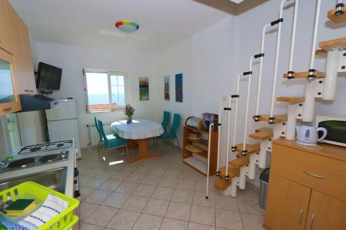 a kitchen with a table and a table and a shelf at Apartments Delminium in Lun