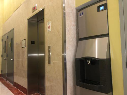 a row of elevators in a bathroom at Elmhurst Hotel in Queens