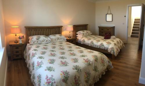 una camera con due letti e due lampade di Conway's Cottage with Sea View Nestling by Cliffs-of-Moher a Liscannor