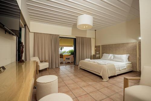 ein Hotelzimmer mit einem Bett und einem Tisch in der Unterkunft Ammos Beachfront Confortable Rooms - Adults only in Vasilikos