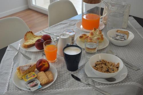een tafel met borden ontbijtproducten en jus d'orange bij B&B La Rosa dei Venti in Altamura