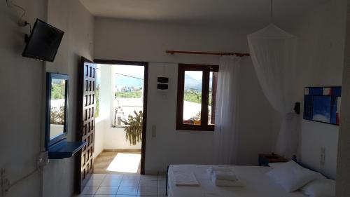 Habitación blanca con cama y ventana en Aeolos Hotel Apartments, en Gythio