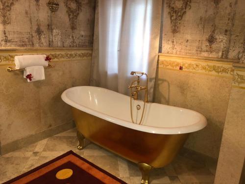 a bath tub in a bathroom with a curtain at Hotel Punta Maquignaz in Breuil-Cervinia