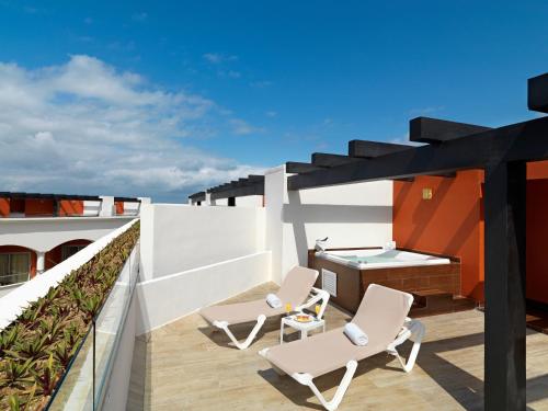 a balcony with two chairs and a sink at Hard Rock Hotel Riviera Maya - All Inclusive in Puerto Aventuras