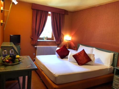 a hotel room with a bed and a table with a bowl of fruit at Hotel Punta Maquignaz in Breuil-Cervinia