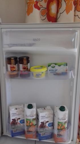 an open refrigerator filled with milk and eggs at Potokia Rooms in Kakóvatos
