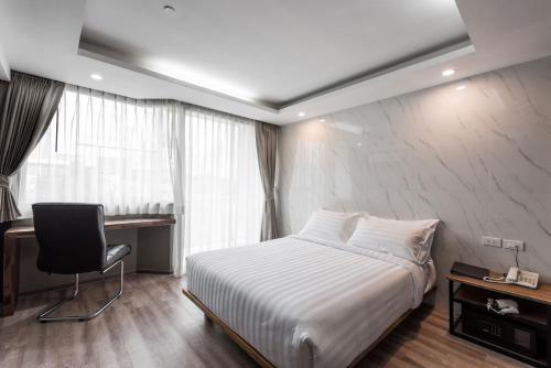 a bedroom with a bed and a desk and a chair at Bangkok City Link Hotel in Bangkok