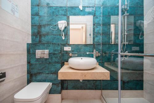 a bathroom with a sink and a toilet and a mirror at Tonusi Luxe Hotel in the Historic City Center in Tbilisi City