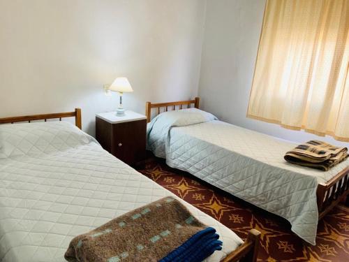 Curuzú CuatiáにあるContinental Hotelのベッドルーム1室(ベッド2台、ランプ、窓付)