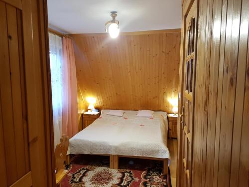 a small bedroom with a bed and a window at Willa Irys in Bukowina Tatrzańska
