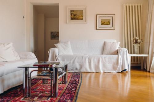 a living room with a white couch and a table at Exclusive Aparthotel La Reunion in Ravenna