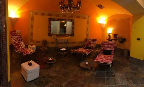 a living room with chairs and a mirror at Hotel Punta Maquignaz in Breuil-Cervinia