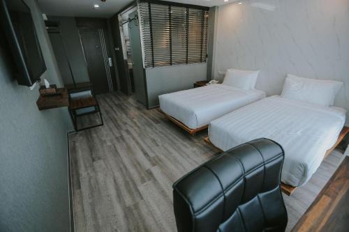a hotel room with two beds and a couch at Bangkok City Link Hotel in Bangkok