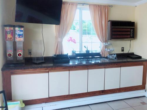 a kitchen with a counter with a stove and a window at Sunflower Inn in Galloway