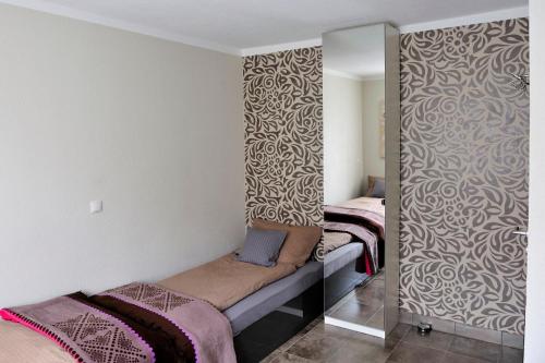 a room with two beds and a mirror at Ferienzimmer Ellisee, kontaktloser Check-in in Friedrichshafen