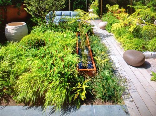 a garden with tall plants and aitatingificialificialificialificialificialificialificialificial at Bed and garden in Knokke-Heist
