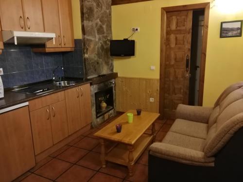 cocina con sala de estar con sofá y mesa en Alojamientos Rurales El Fontano, en Galende