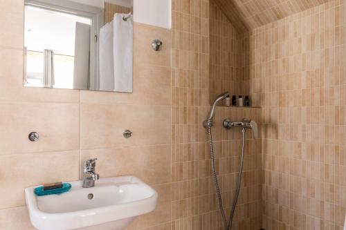 La salle de bains est pourvue d'une douche et d'un lavabo. dans l'établissement Mon-Repo Suites, à Corfou