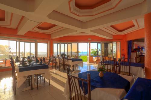 une salle à manger avec tables, chaises et fenêtres dans l'établissement UMH Tarik Hotel, à Tanger