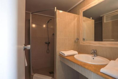 a bathroom with a shower and a sink and a mirror at UMH Tarik Hotel in Tangier