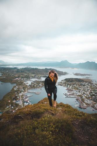a woman standing on top of a mountain at Solsiden Brygge Rorbuer in Ballstad
