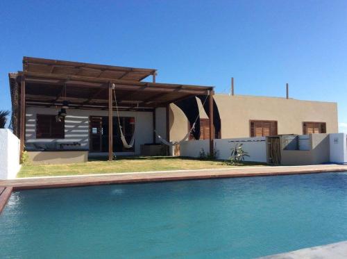 a house with a swimming pool in front of a house at maison au zenit in Maceio