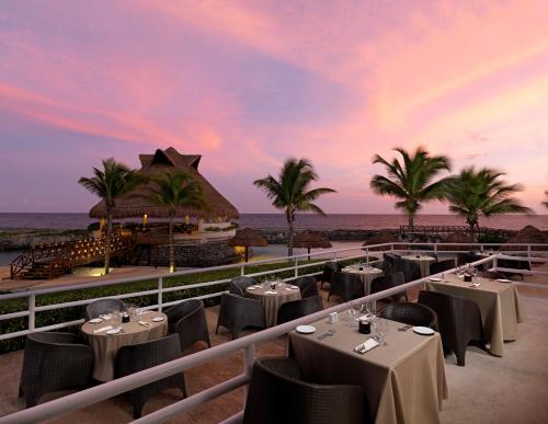 a restaurant on the beach with tables and chairs at Hard Rock Hotel Riviera Maya - Heaven Adults Only - All Inclusive in Puerto Aventuras