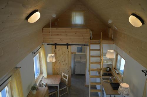 a tiny house with a staircase and a desk at Osada Leonówka Bieszczady in Cisna