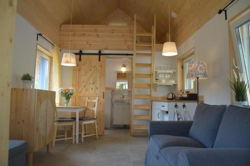 a living room and kitchen with a couch and a table at Osada Leonówka Bieszczady in Cisna