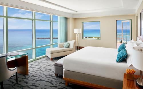 a hotel room with a bed and a couch and windows at The Reef at Atlantis in Nassau