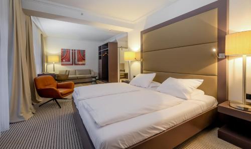 a hotel room with a large bed and a chair at Zum Löwen Design Hotel Resort & Spa in Duderstadt