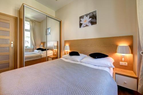 - une chambre avec un grand lit et un grand miroir dans l'établissement DR Apartments - Frank, à Sopot