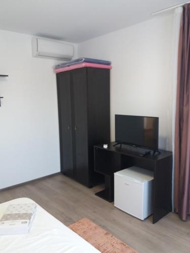 a bedroom with a black cabinet and a television at Stella Maris in Techirghiol