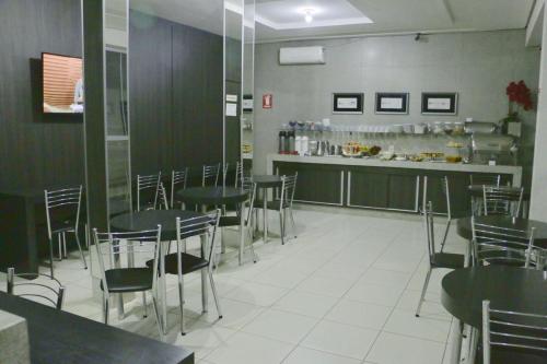a dining room with tables and chairs and a counter at Grande Hotel in Gurupi