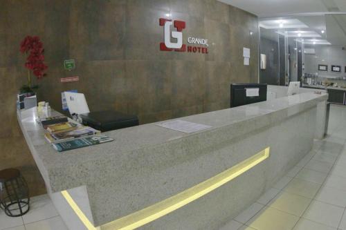 a lobby of a coffee hotel with a reception counter at Grande Hotel in Gurupi