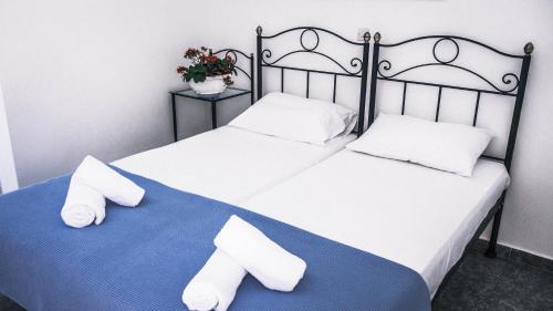 two beds with white towels on a blue blanket at Maria's View in Ios Chora