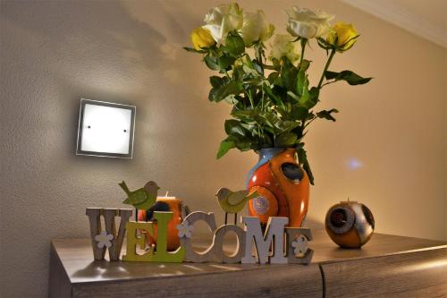 a vase with flowers on a shelf with a sign at bei den Geißens in Aldersbach