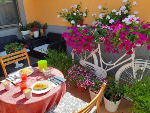 una mesa y sillas con flores y una bicicleta en Da Laura, en Lucca