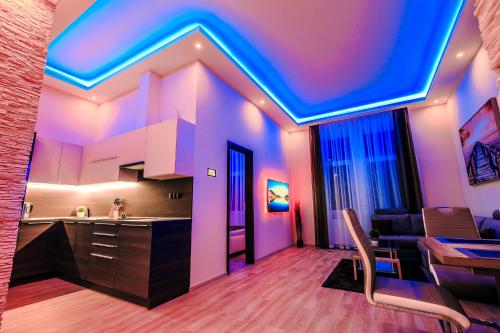 a kitchen with purple and blue lights on the ceiling at Luxury Smart Apartments in Szeged