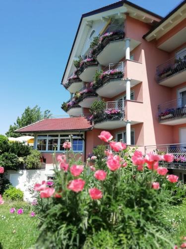 a pink building with flowers in front of it at Hotel-Restaurant Walserhof in Wasserburg am Bodensee