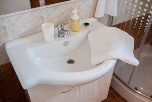 un lavabo blanco con una toalla. en Apartments MARIO, en Malinska