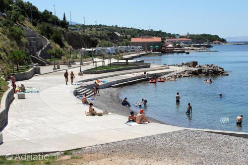 a group of people swimming in a body of water at Josipa & Jelena Apartment in Senj