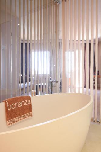 a white bath tub in a room with windows at Palace Bonanza Playa Resort & SPA by Olivia Hotels Collection in Illetas