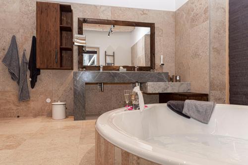 a bathroom with a large tub and a sink at Ferienhaus am See mit Sauna und Whirlpool in Wienerbruck