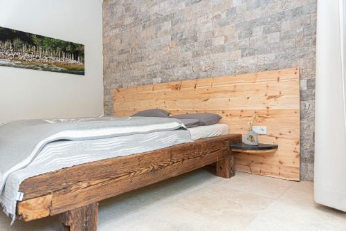 a wooden bed in a room with a brick wall at Ferienhaus am See mit Sauna und Whirlpool in Wienerbruck